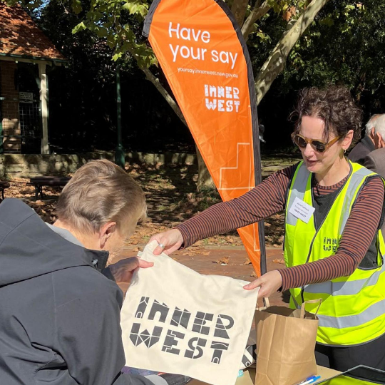 Person with another person providing a bag that reads Inner West